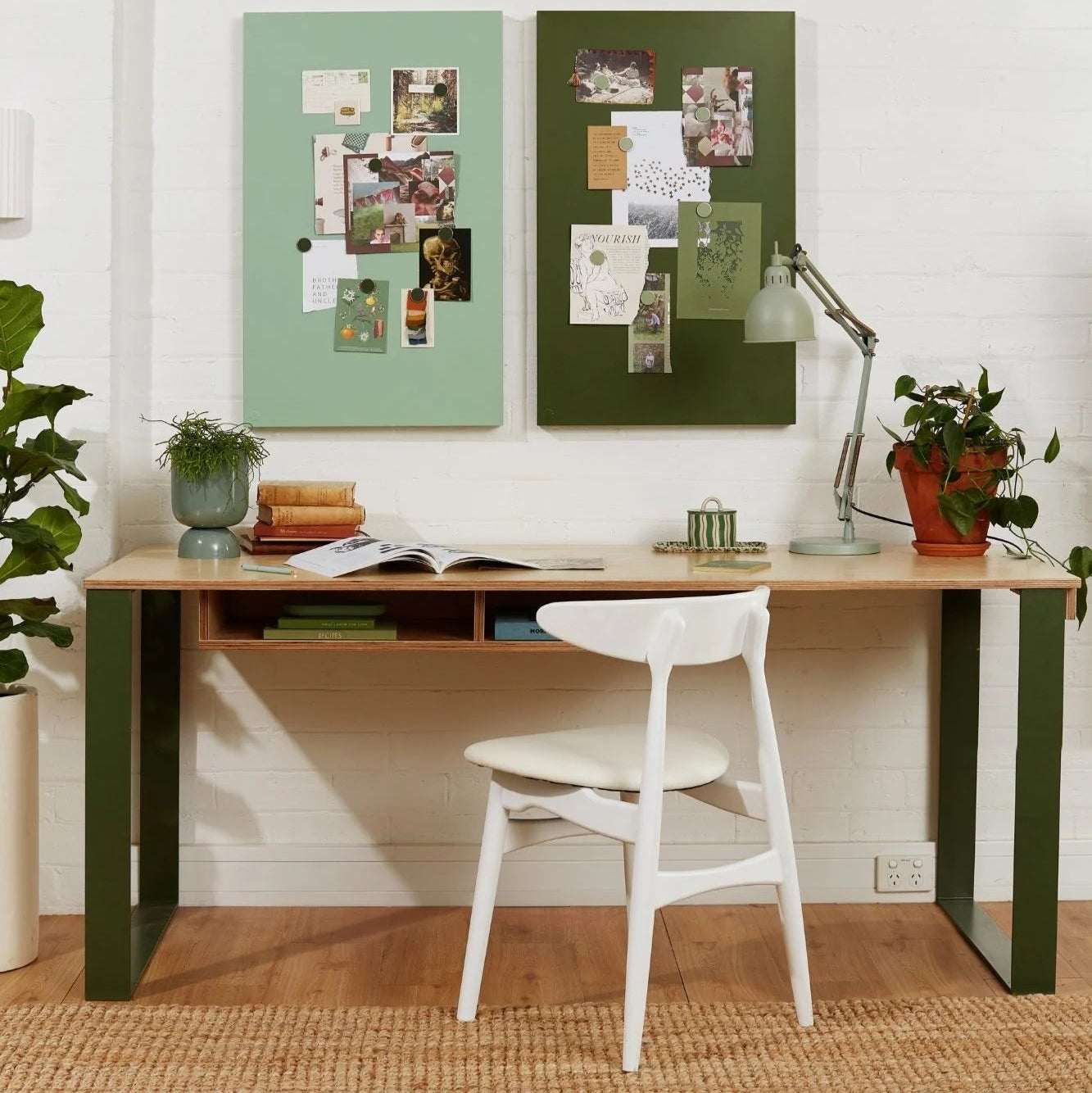 Home office with a wooden desk, white chair, and decorative elements on a white wall.