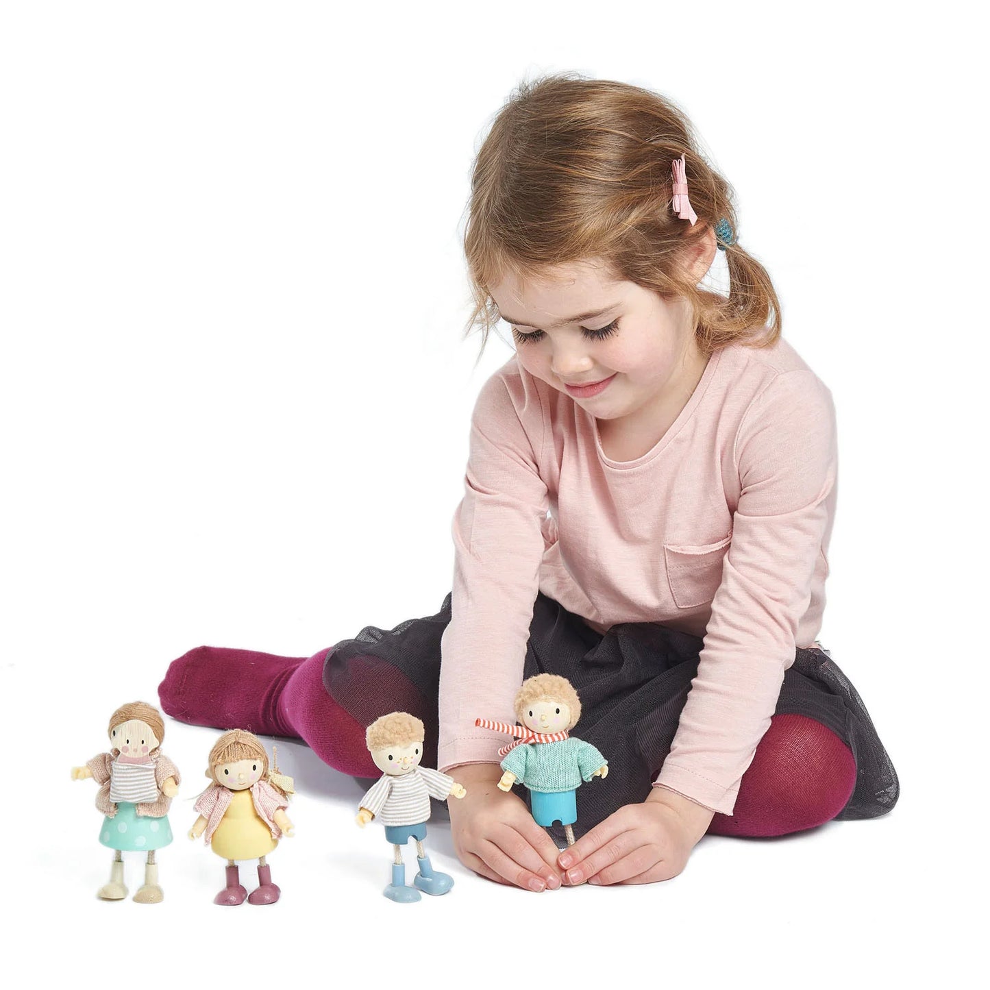 Young girl playing with toy figures on a white background