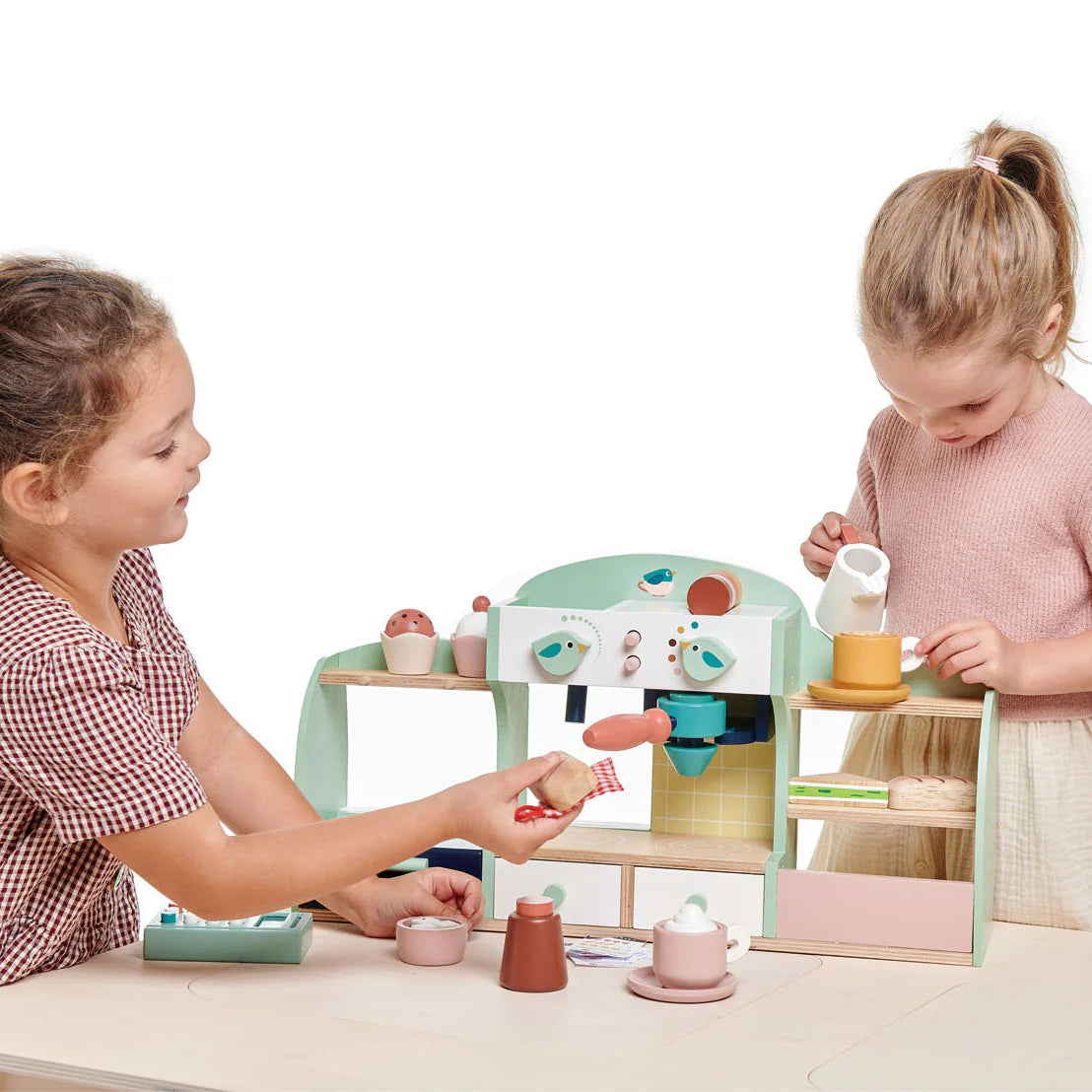 Two children playing with a toy kitchen set on a white background
