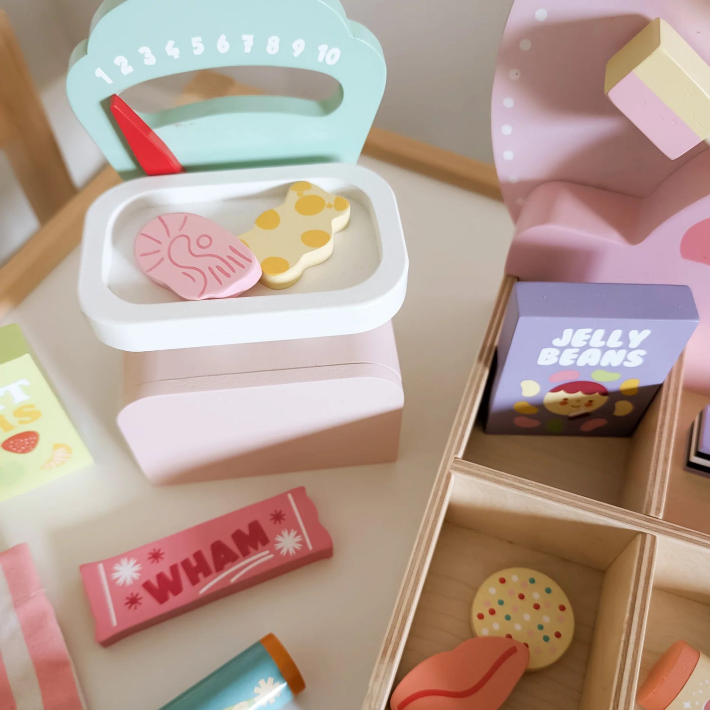 Colorful toy candy set with a box labeled 'Jelly Beans' on a wooden surface.
