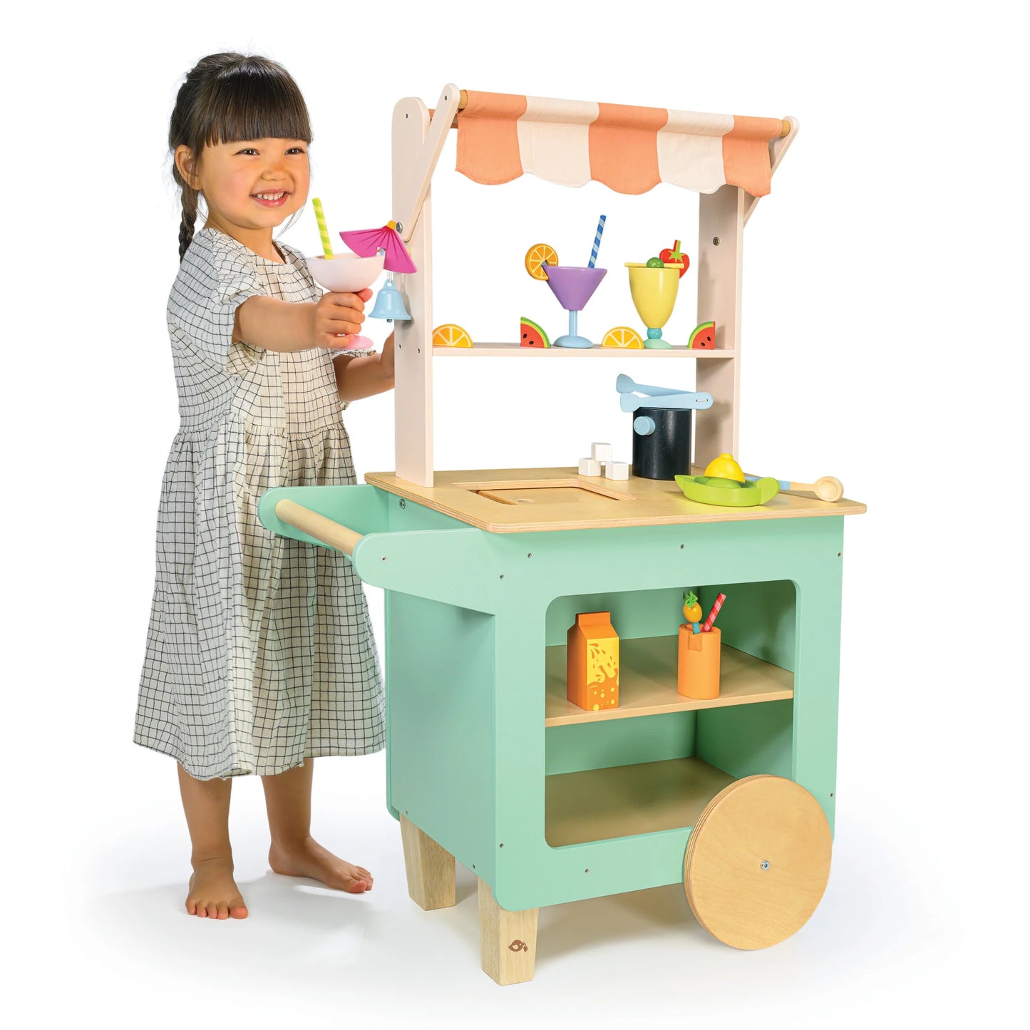 Child playing with a toy kitchen set on a white background
