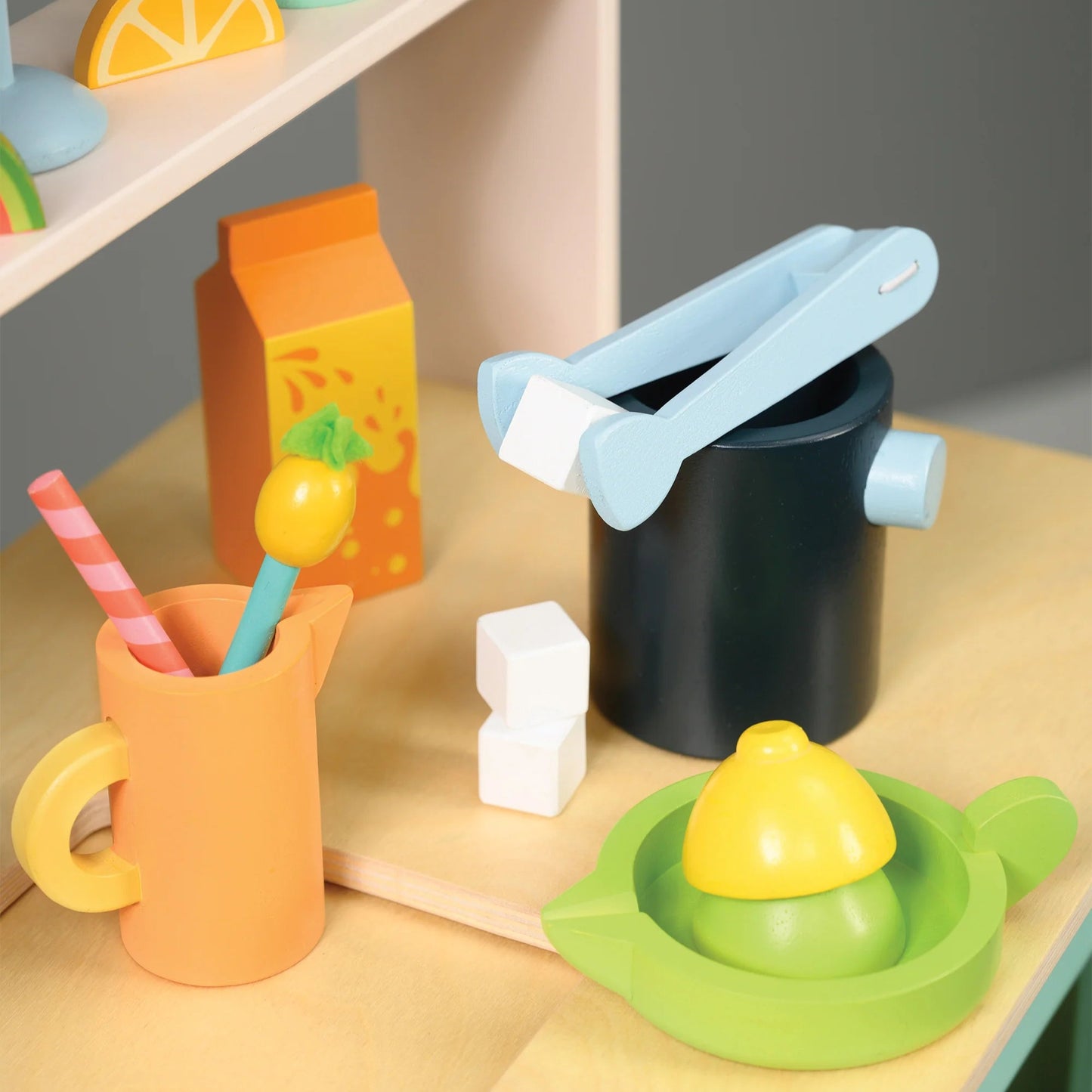 Colorful toy kitchen set with various items on a wooden surface