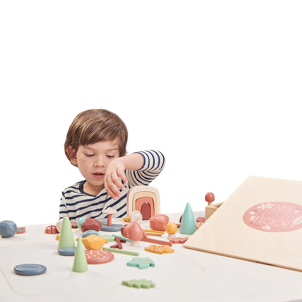 Child playing with colorful wooden toys on a white surface