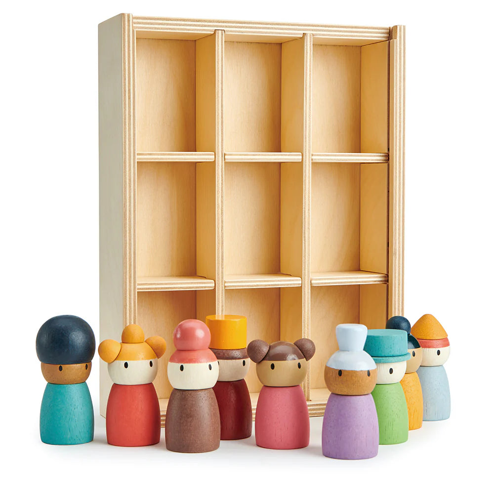 Set of colorful wooden dolls in front of a wooden shelf on a white background