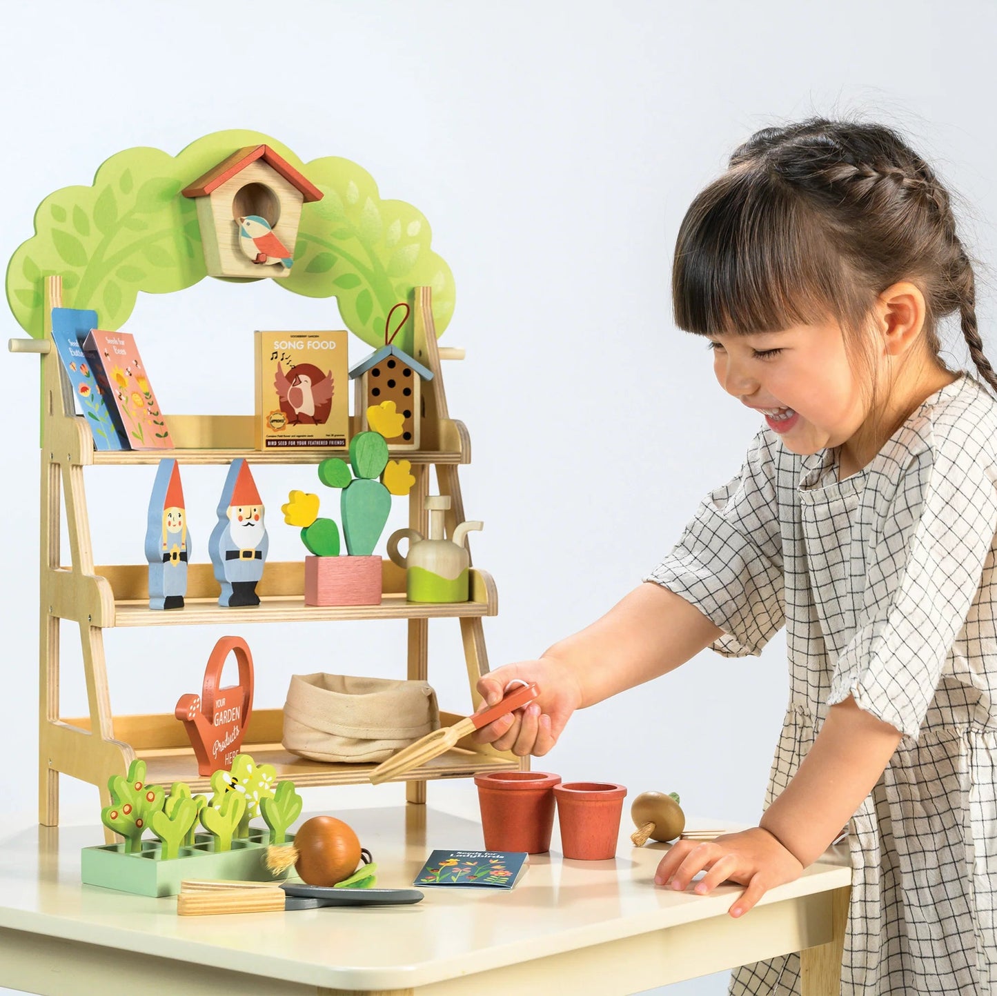 Child playing with a toy garden set on a table