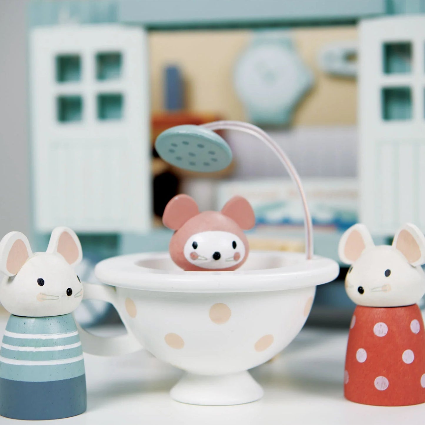 Wooden toy mice with a bathtub and shower in a toy house setting