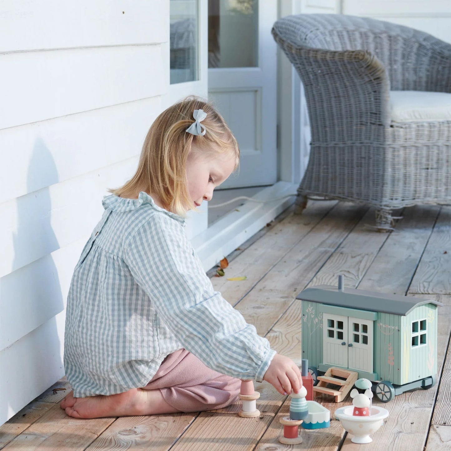 Child playing with toys on a wooden deck