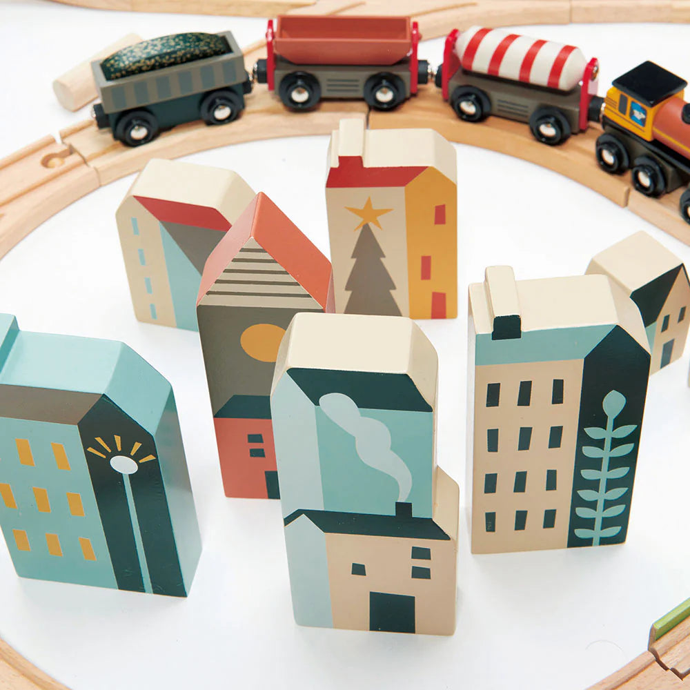Wooden toy train set with colorful houses on a white background