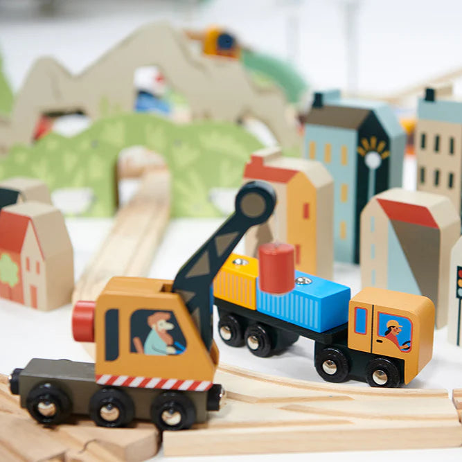 Wooden toy train set with buildings and trees on a track