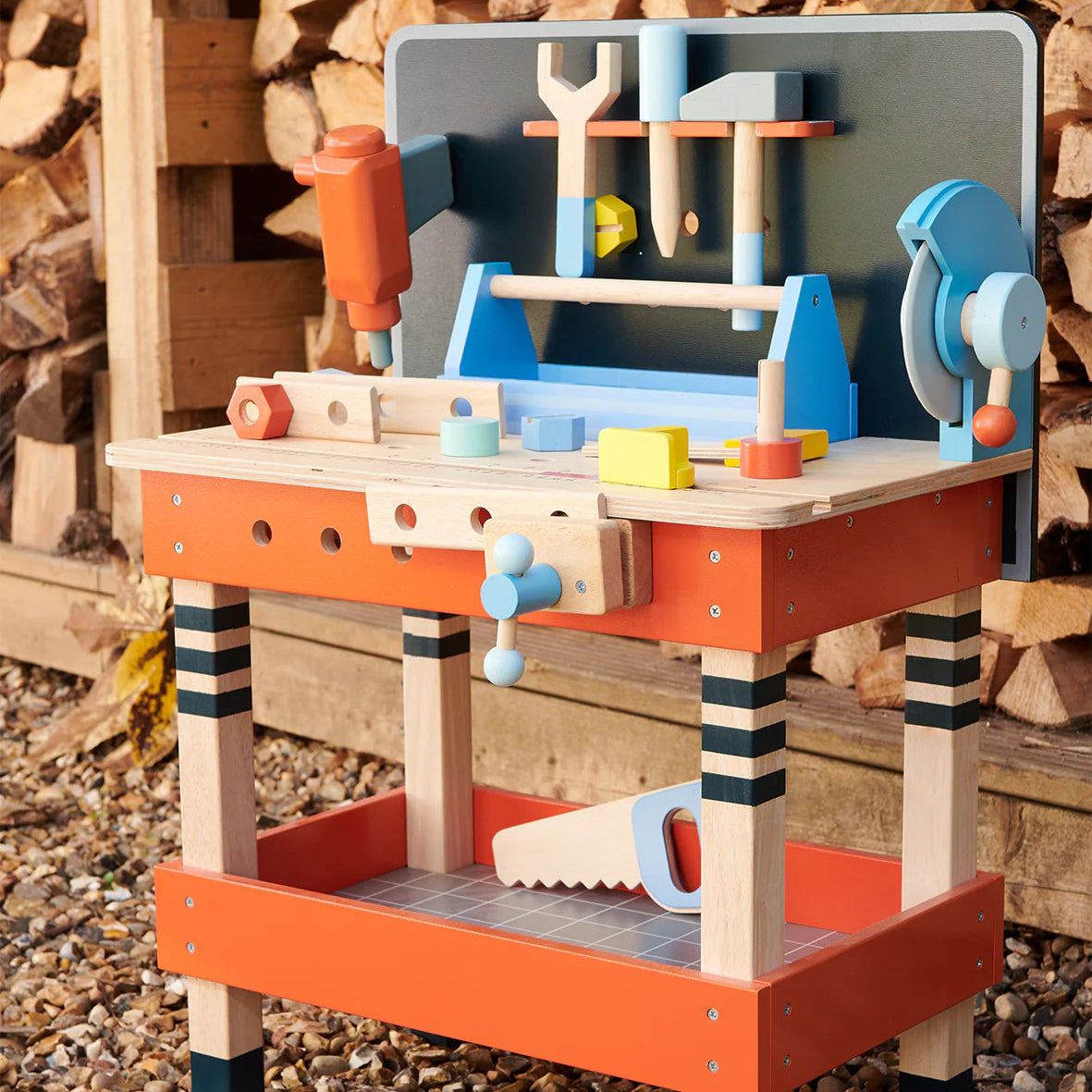 Wooden toy workbench with tools against a wooden background