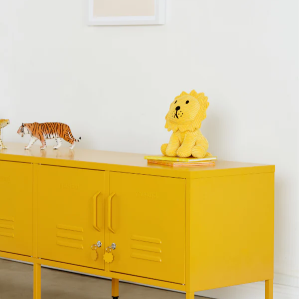 Yellow cabinet with decorative items in a room with white walls and framed artwork.