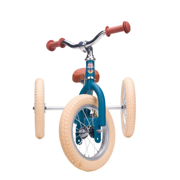 Children's balance bike with blue frame and beige tires on a white background