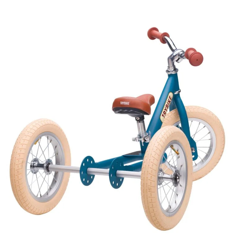 Blue children's tricycle with beige tires on a white background