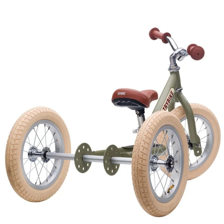 Children's tricycle with tan tires and red handlebar grips on a white background