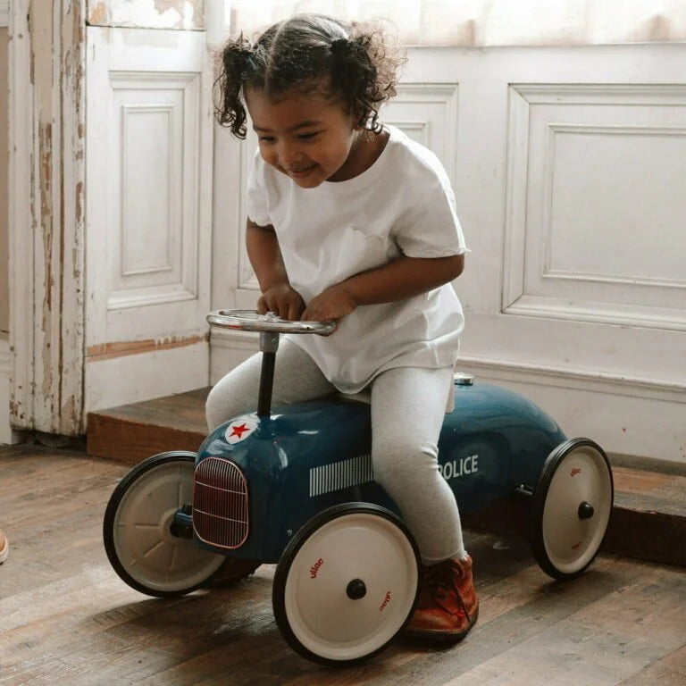 Child playing with a toy police car indoors