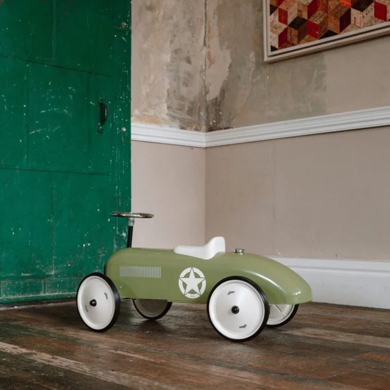 Khaki green ride on toy car in a room