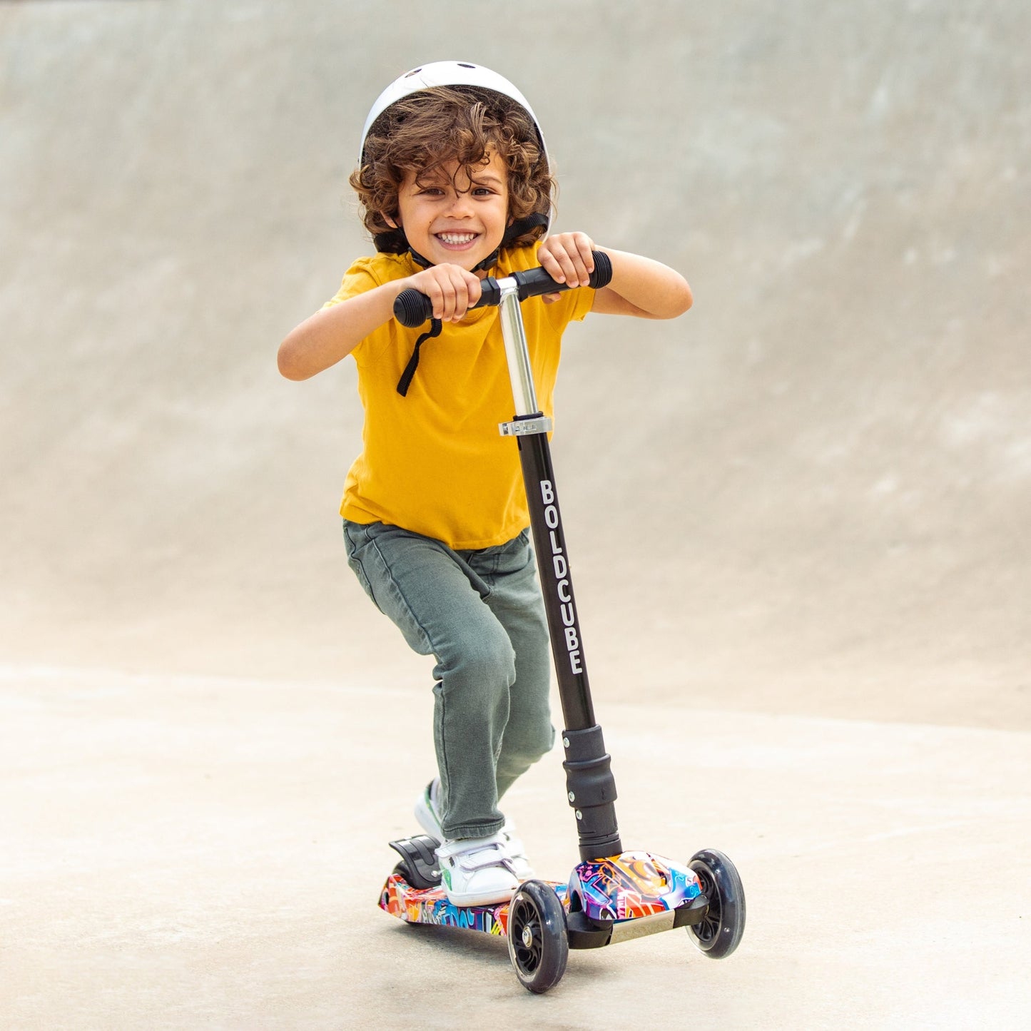 Child riding a scooter with a helmet on a plain background