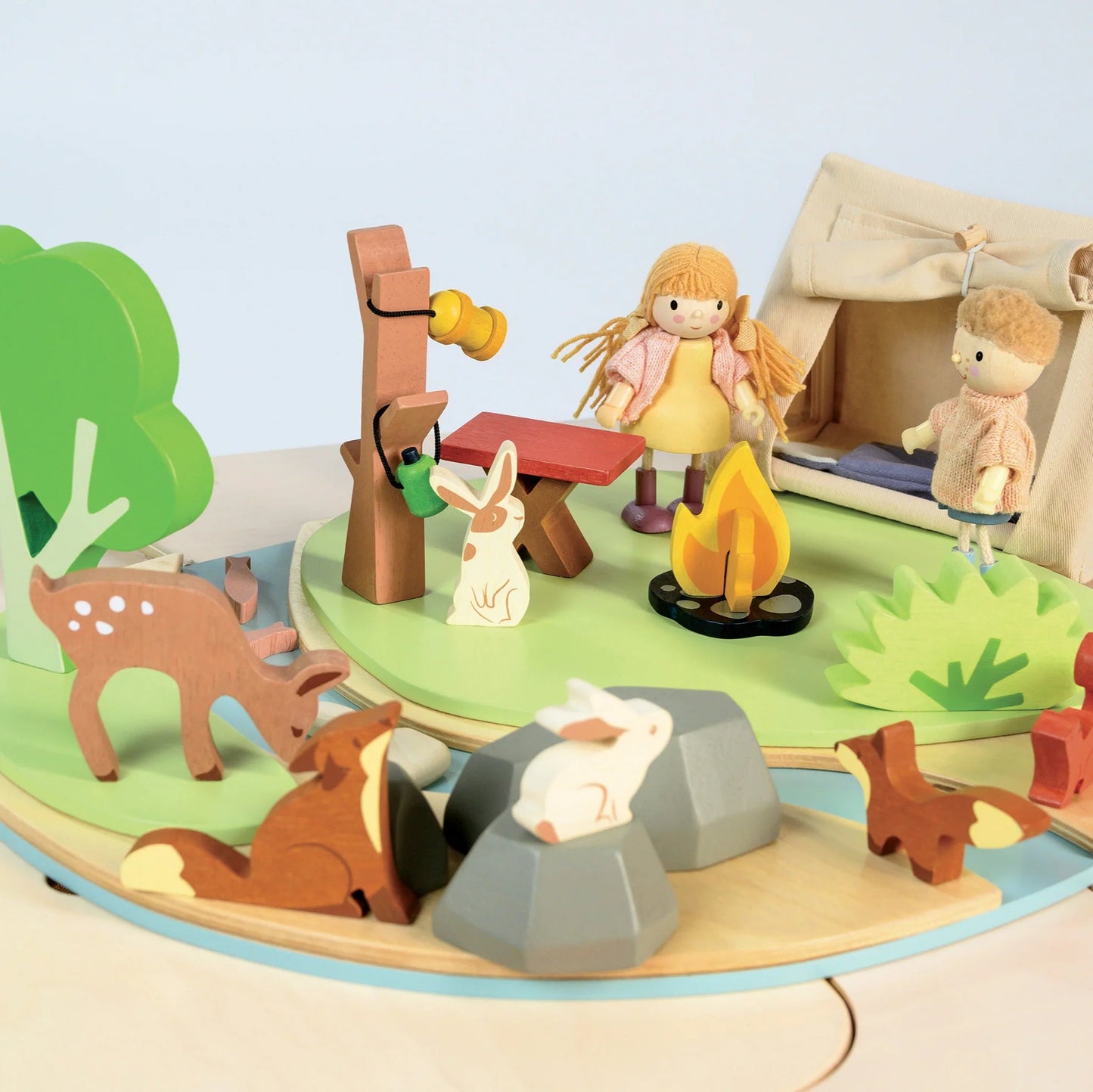 Wooden toy set with animals and people in a forest scene