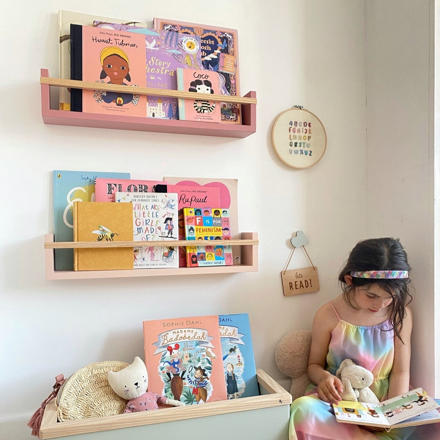 Child reading a book in a room with colorful shelves and toys.