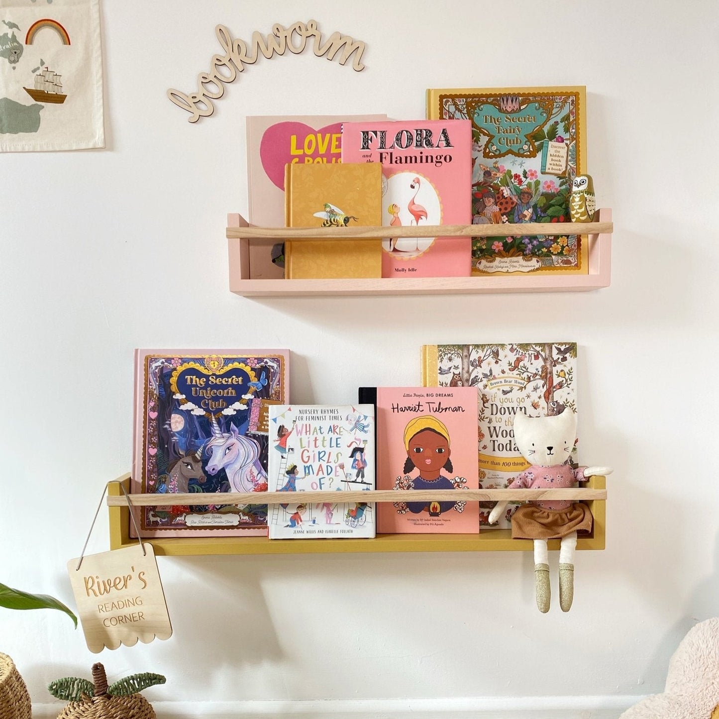 Children's bookshelves with books and decorative items against a white wall.