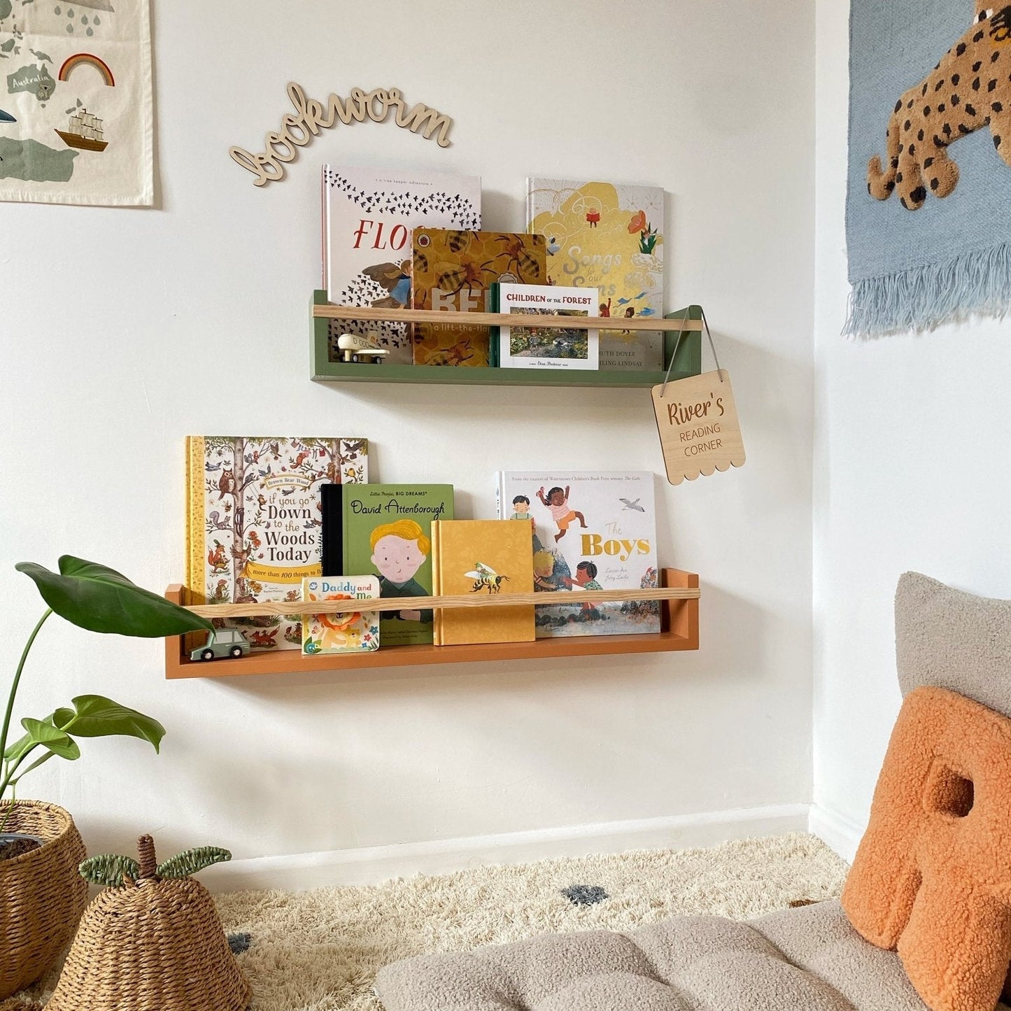 Children's room with a bookshelf, books, and decorative items on a white wall.