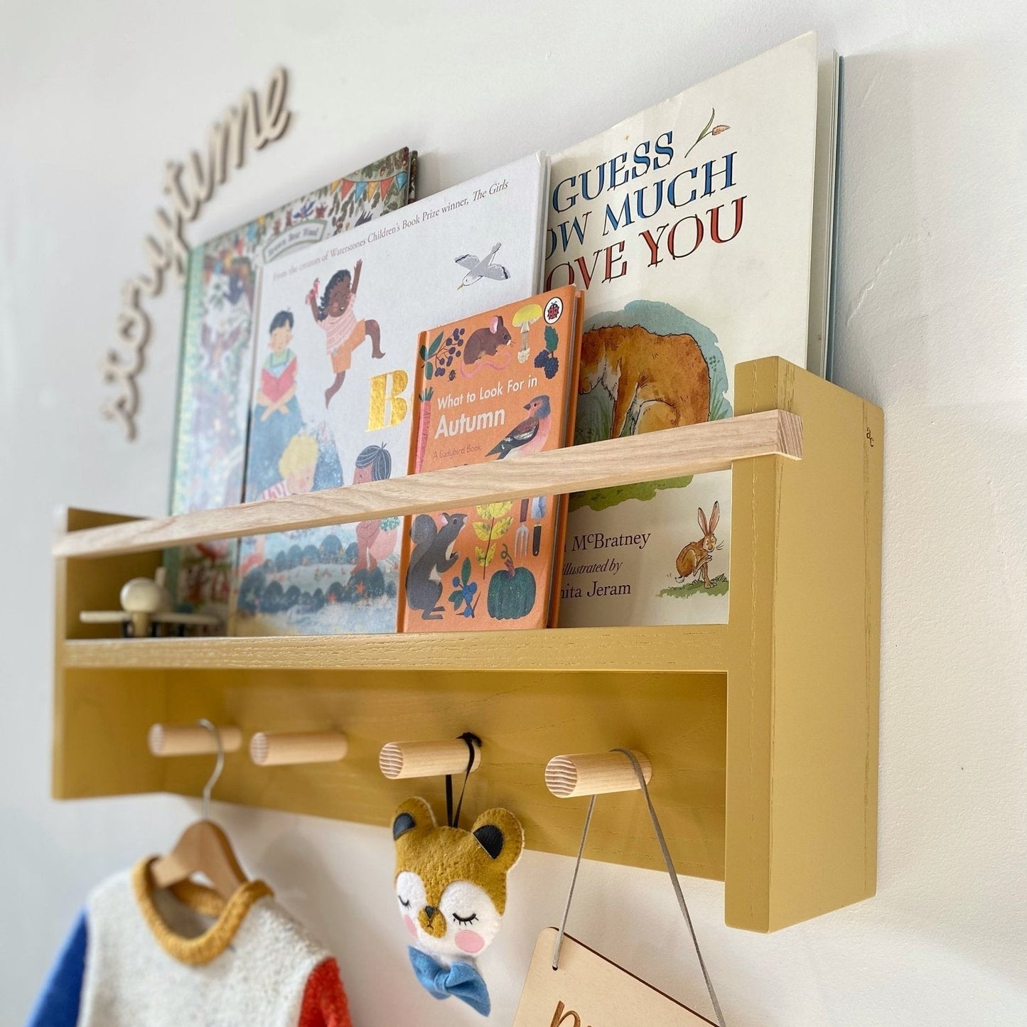 Wooden shelf with children's books and a tag on a wall