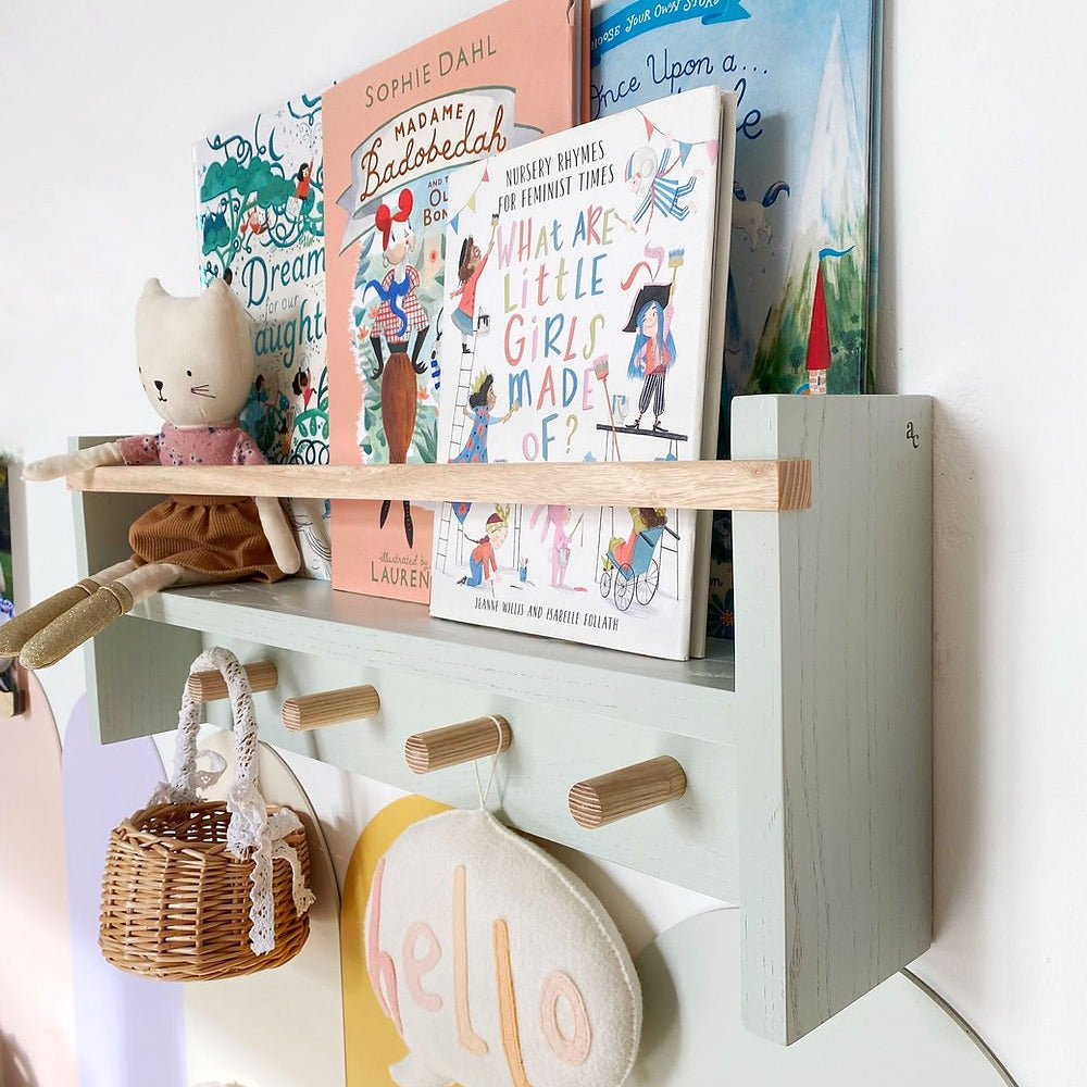Children's bookshelf with books and toys against a white wall