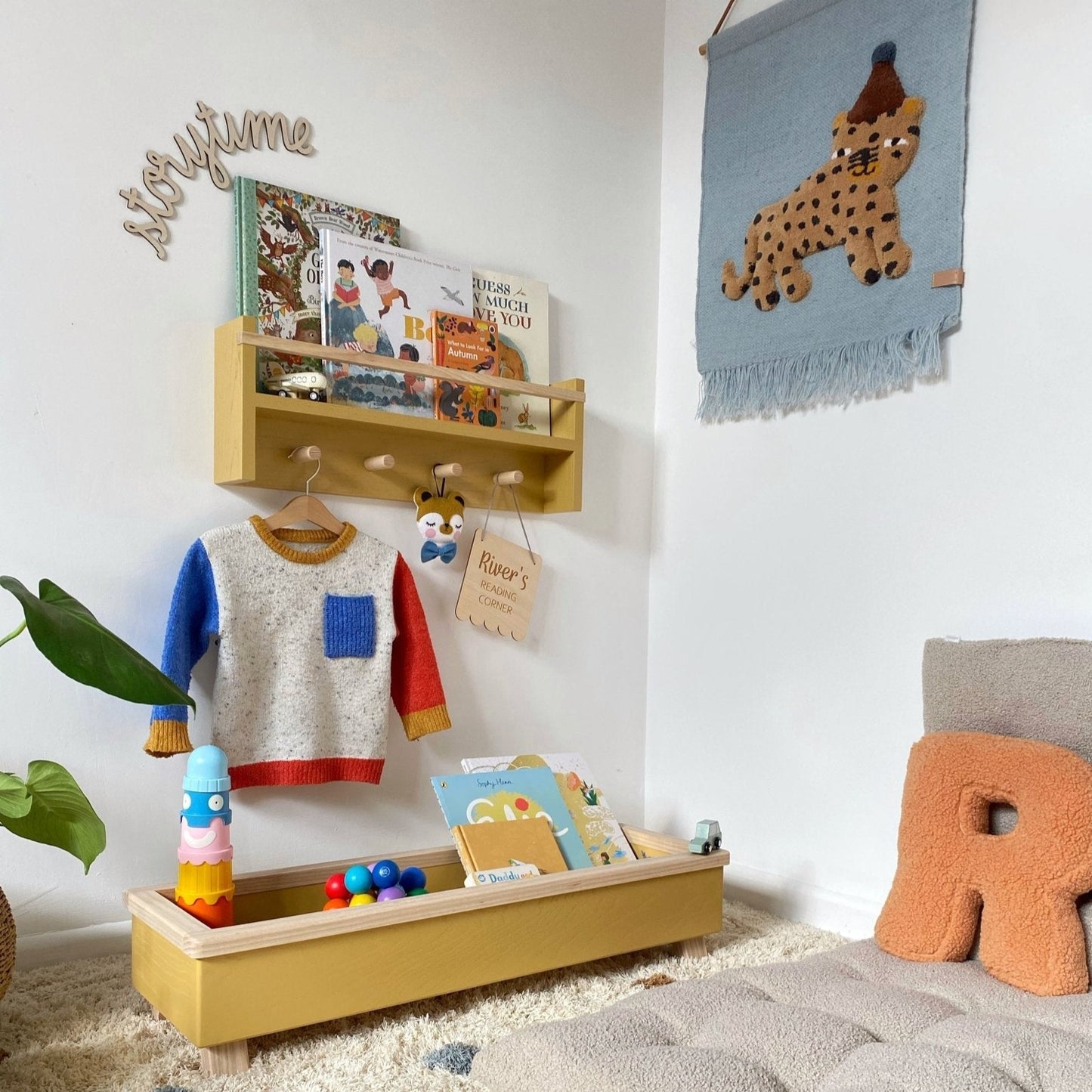 Children's playroom with a shelf, books, and toys on a carpeted floor.