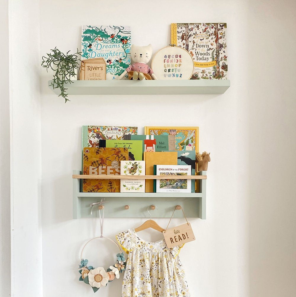 Children's room with shelves displaying books, a dress, and decorative items.