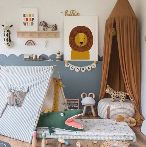 Children's playroom with a tent, toys, and wall decorations.