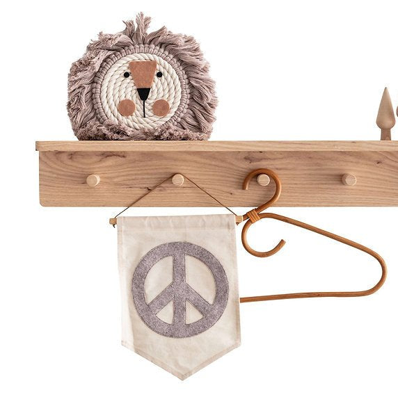Wooden shelf with decorative items including a peace symbol banner and a plush lion toy.