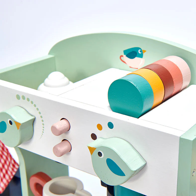 Children's play kitchen set with colorful toy ingredients on a light blue background