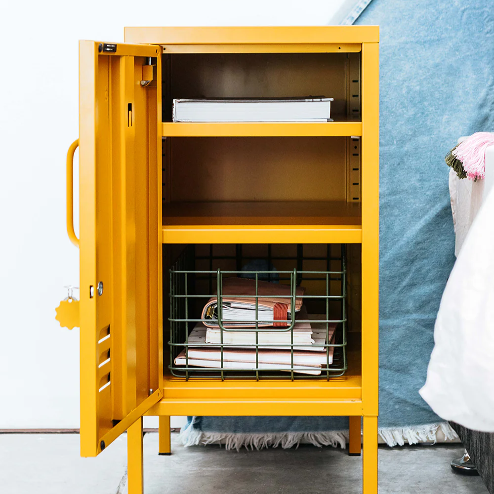Yellow storage cabinet with open door showing shelves and items inside, against a white wall.