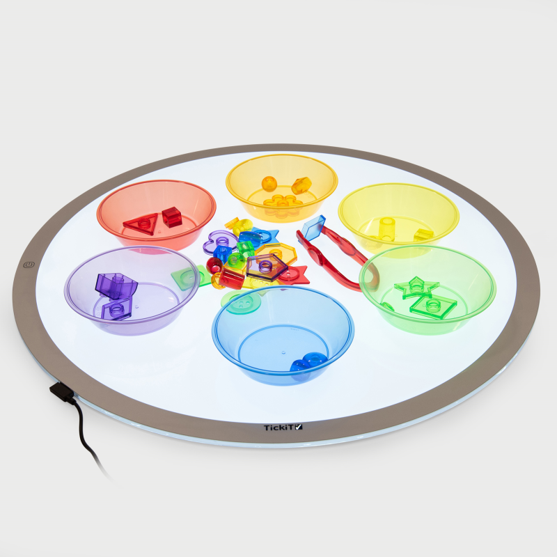 Round light-up tray with colourful compartments and toys on a white background