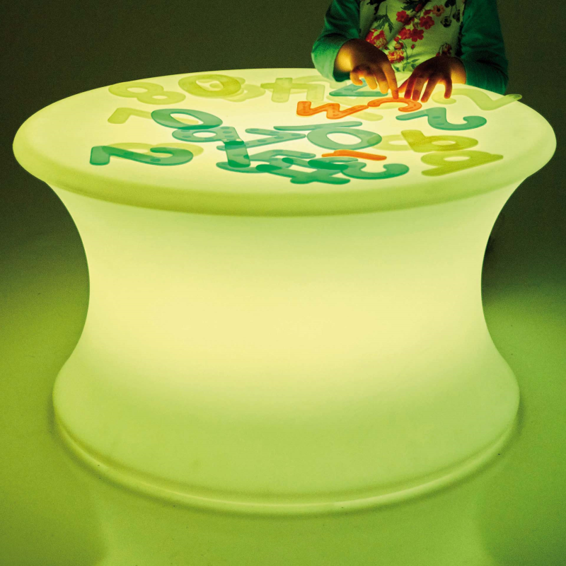 Children's sensory table with glowing numbers and letters on a dark background