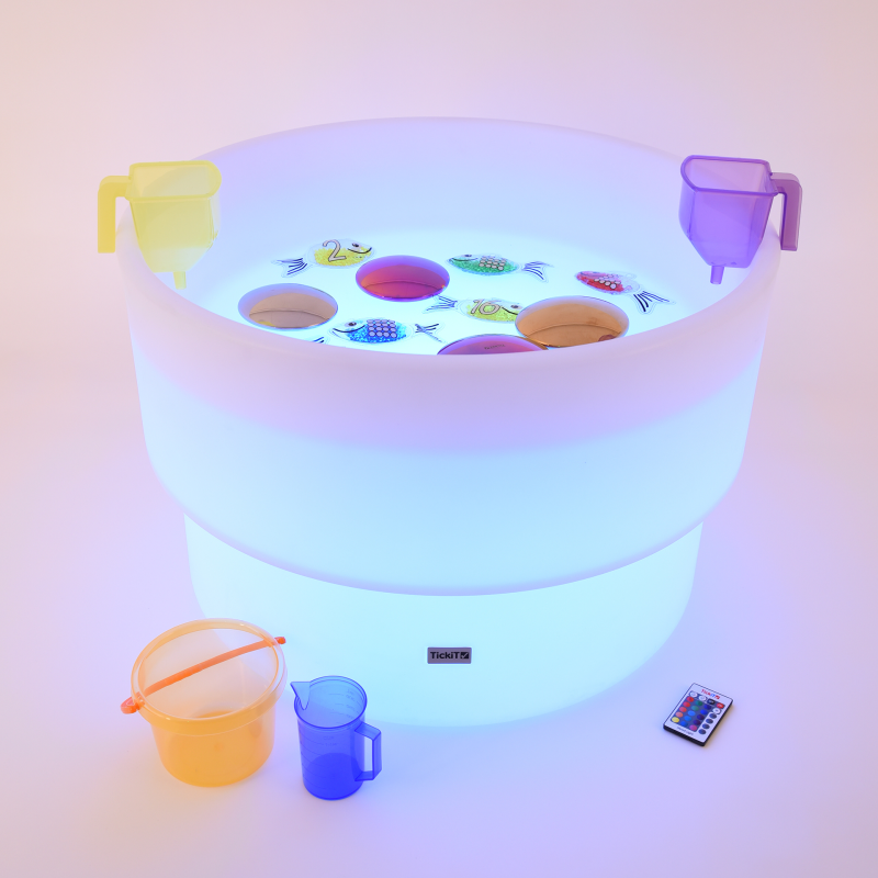 Light-up play table with colorful toys and cups on a white background