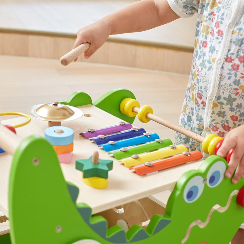 Child playing with a colorful wooden toy set on the walker.