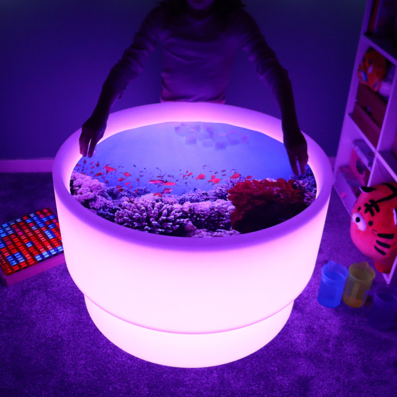 child interacting with a playmat with a sealife scene on a discovery table