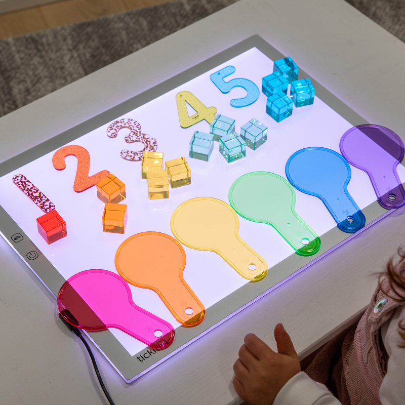 Light-up panel with colourful numbers and shapes on a table.