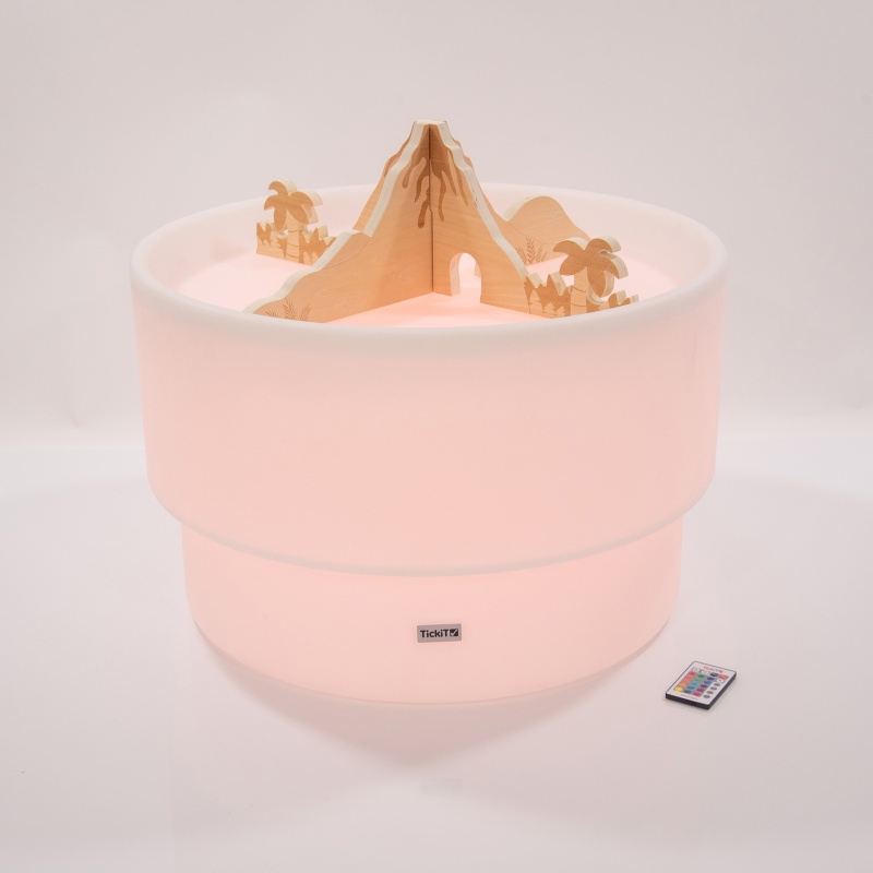 Sensory Play table in a red glow light with wooden jurassic volcano dividers
