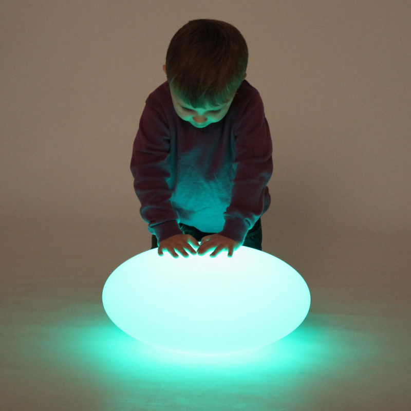 A child standing over a pebble shaped light.