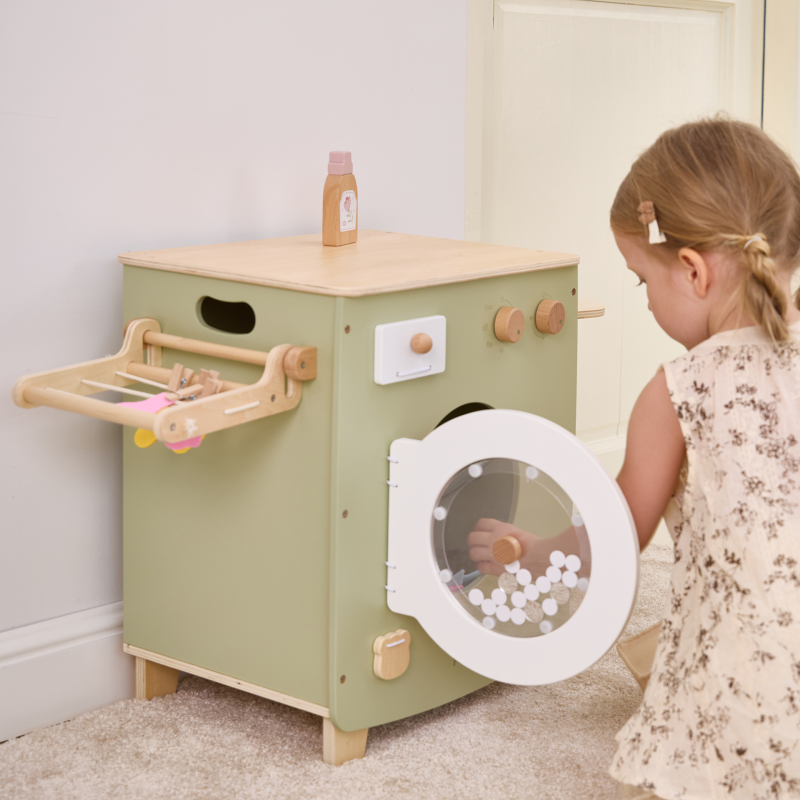 Child playing with a toy washing machine set