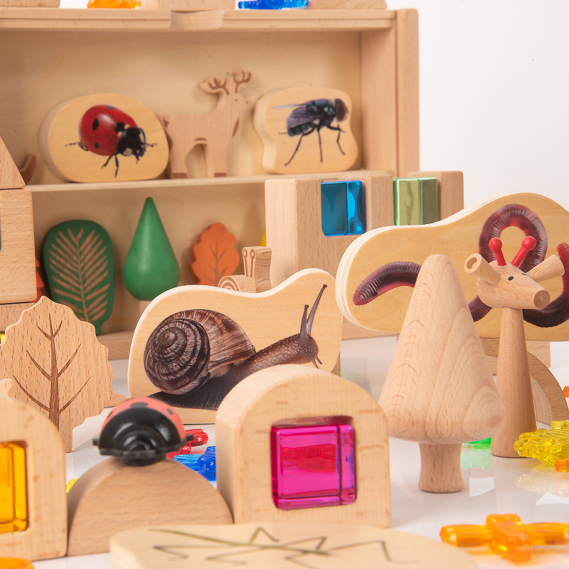 Wooden toys with animal and nature-themed blocks on a shelf.