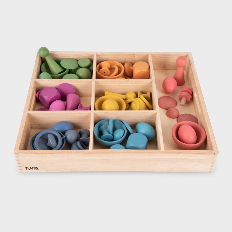 Colorful wooden toys in a wooden box on a white background