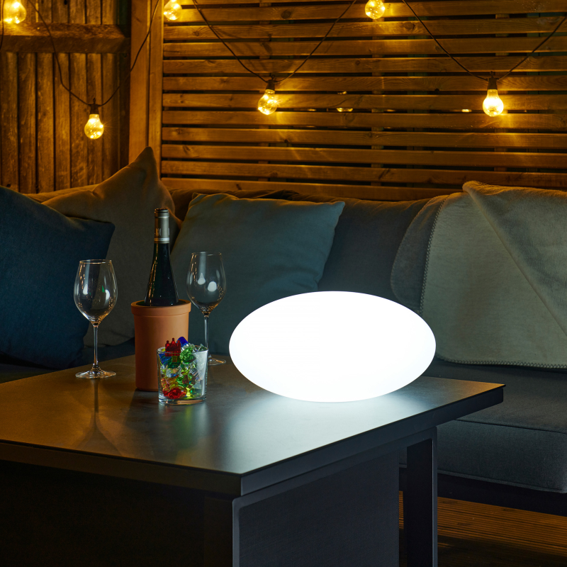 Pebble sensory light on an outside table at night time.