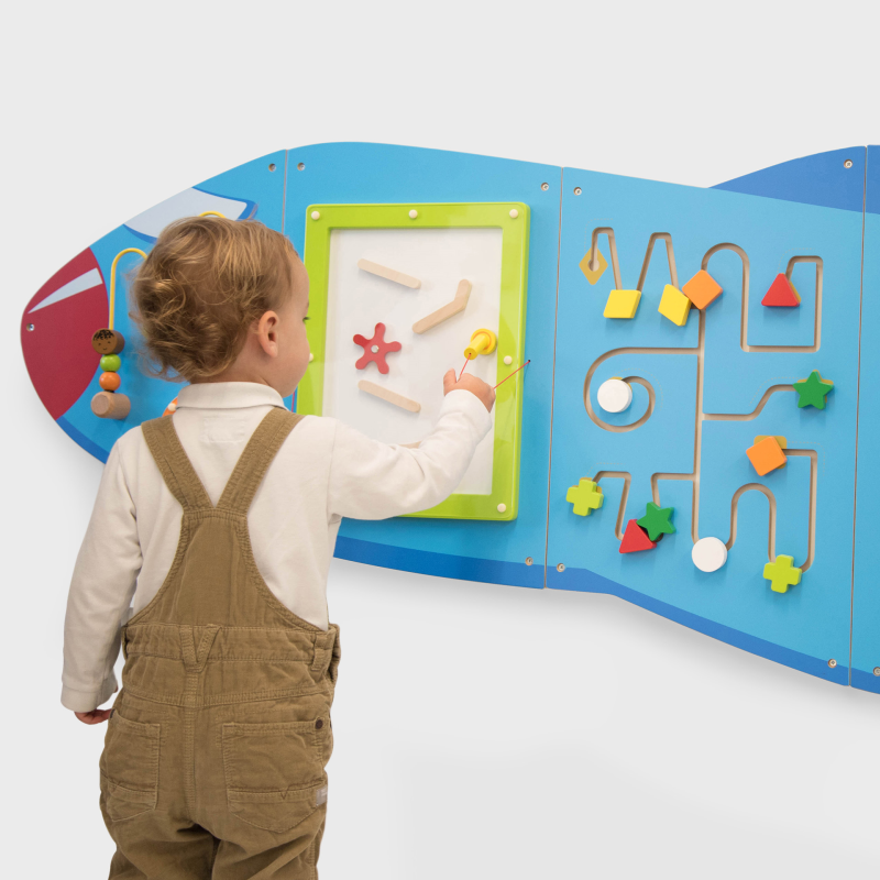 Child playing with a colourful magnetic board on a white background
