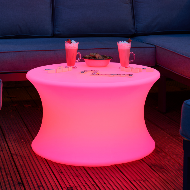 Pink LED sensory table used as a coffee table with drinks and snacks on a wooden deck