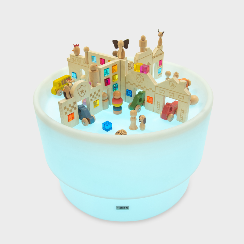 Children's toy set with colourful building blocks and figures on a glowing blue platform.