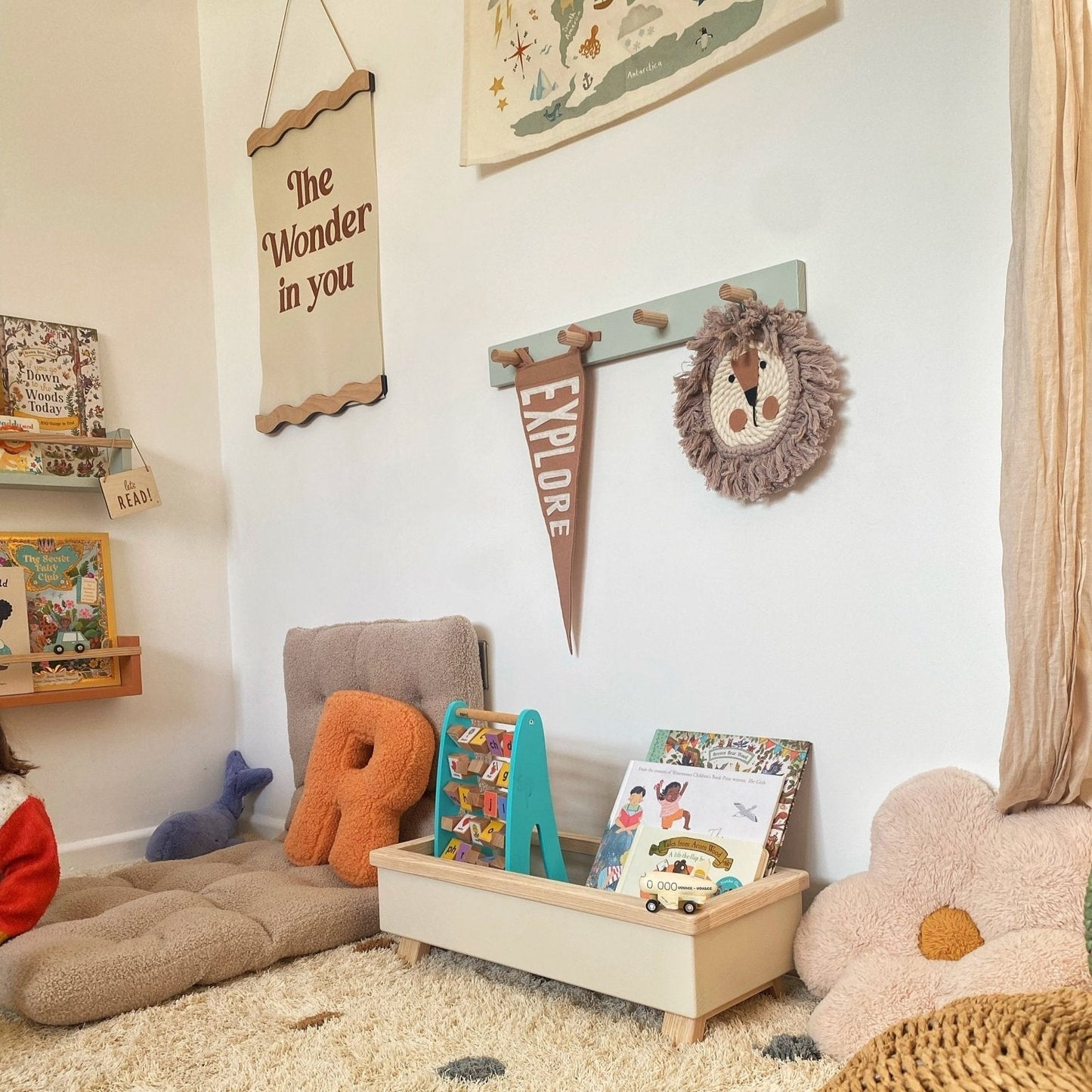 Children's playroom with toys, books, and decorative elements on a carpeted floor.