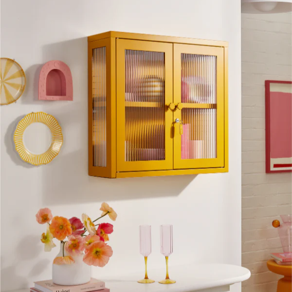 Yellow cabinet on wall with wall decor around.